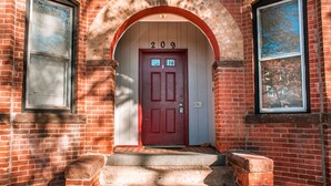 A red door with the number 209, a brick building, and a small window with a picture. - Gorgeous Wooster Sq. apt. - wshr/dryr, parking (New Haven)