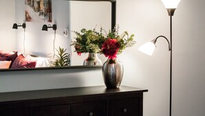A bedroom with a dresser, a mirror, and a bedside lamp. - Gorgeous Wooster Sq. apt. - wshr/dryr, parking (New Haven)