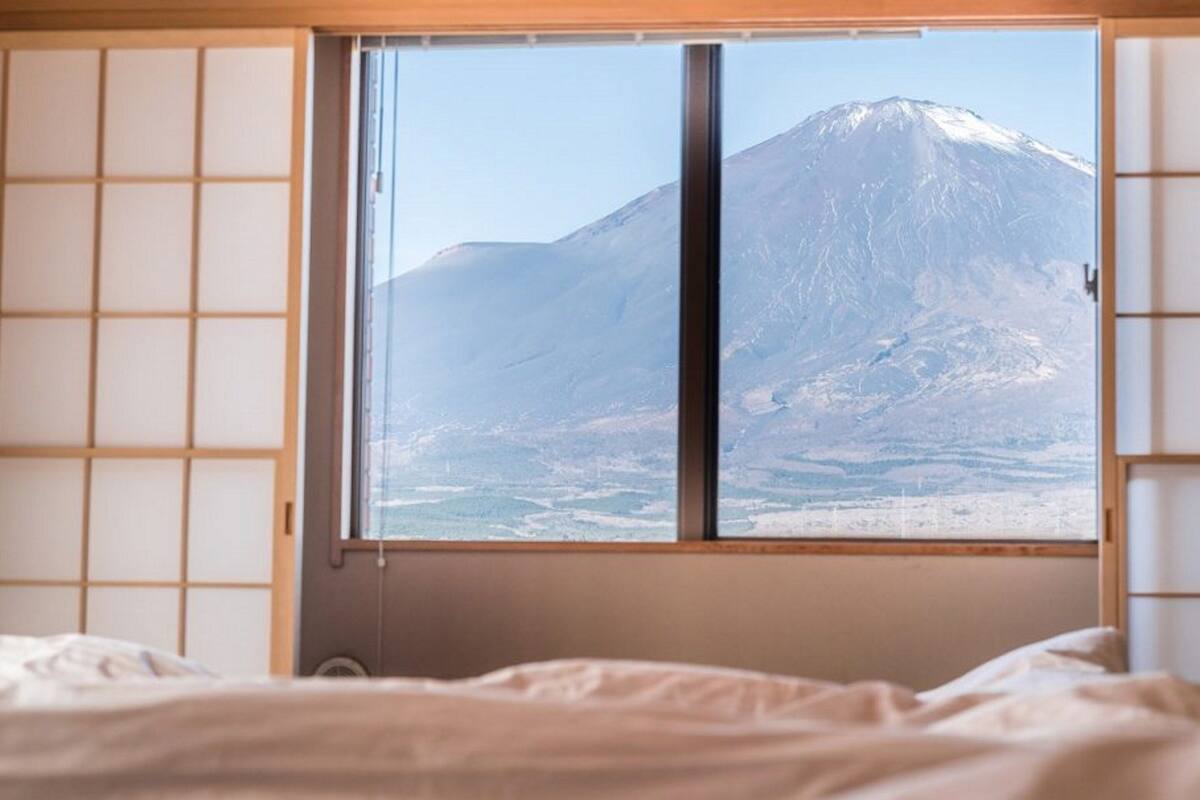 Una stanza con un'ampia finestra che si affaccia su una montagna innevata.