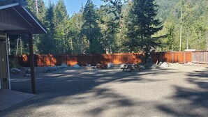 A covered outdoor area with a picnic table and a wooden fence. - RV Flat Lot- Tatoosh Timbers - No Bedroom or Bathroom RV Lot only.  (Packwood)