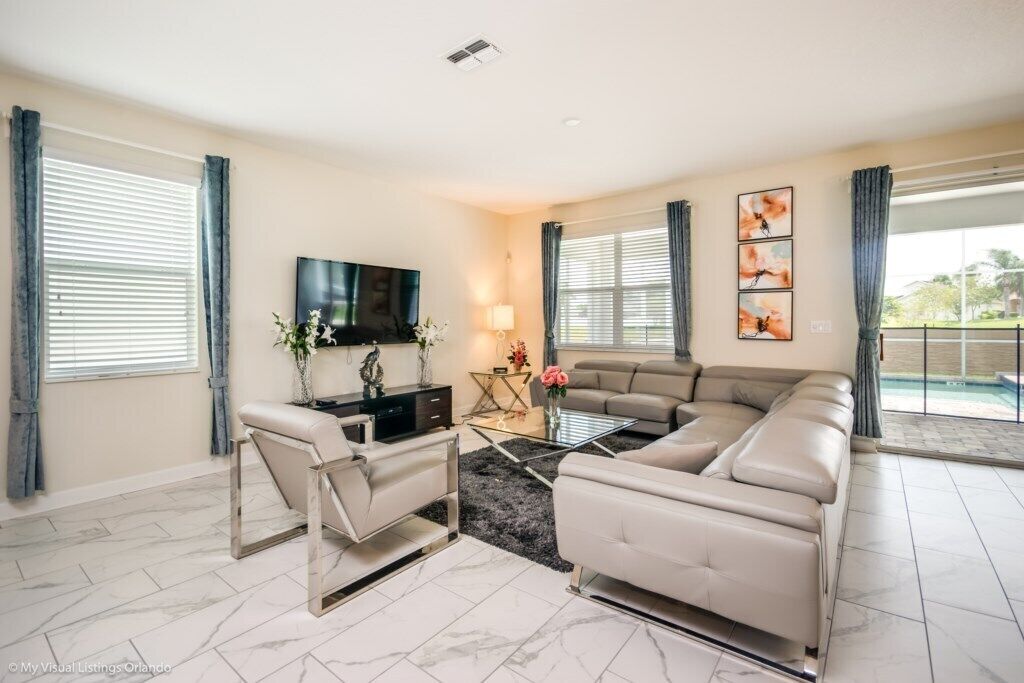 A living room with a sectional sofa, a TV, a coffee table, and a TV stand.