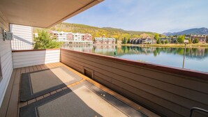 Un balcon donnant sur un lac, avec des bâtiments en arrière-plan.