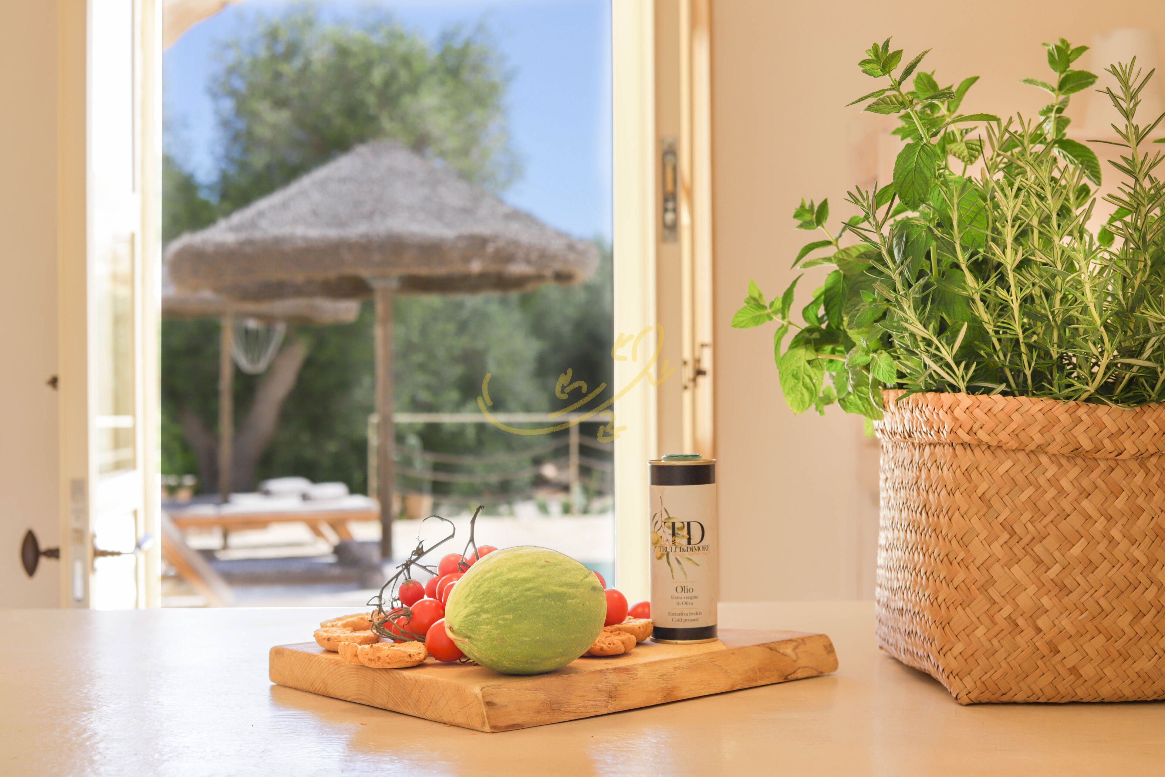 Un tavolo di legno con una guava verde, una bottiglia d'olio d'oliva e un cesto intrecciato con piante verdi.
