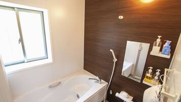 A modern bathroom with a bathtub, a shower, a toilet, and a sink.