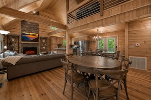 Un intérieur de cabine spacieux, doté d’une cheminée, d’une table à manger en bois et d’un coin salon confortable.