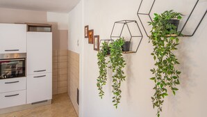 Una cocina moderna con armarios blancos, horno integrado y salpicadero de azulejos.