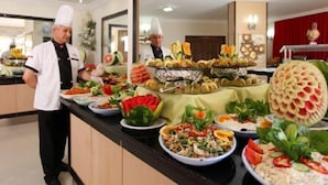 A buffet with various dishes and a large decorative watermelon centerpiece. - Merlin Beach Park Hotel (Alanya)