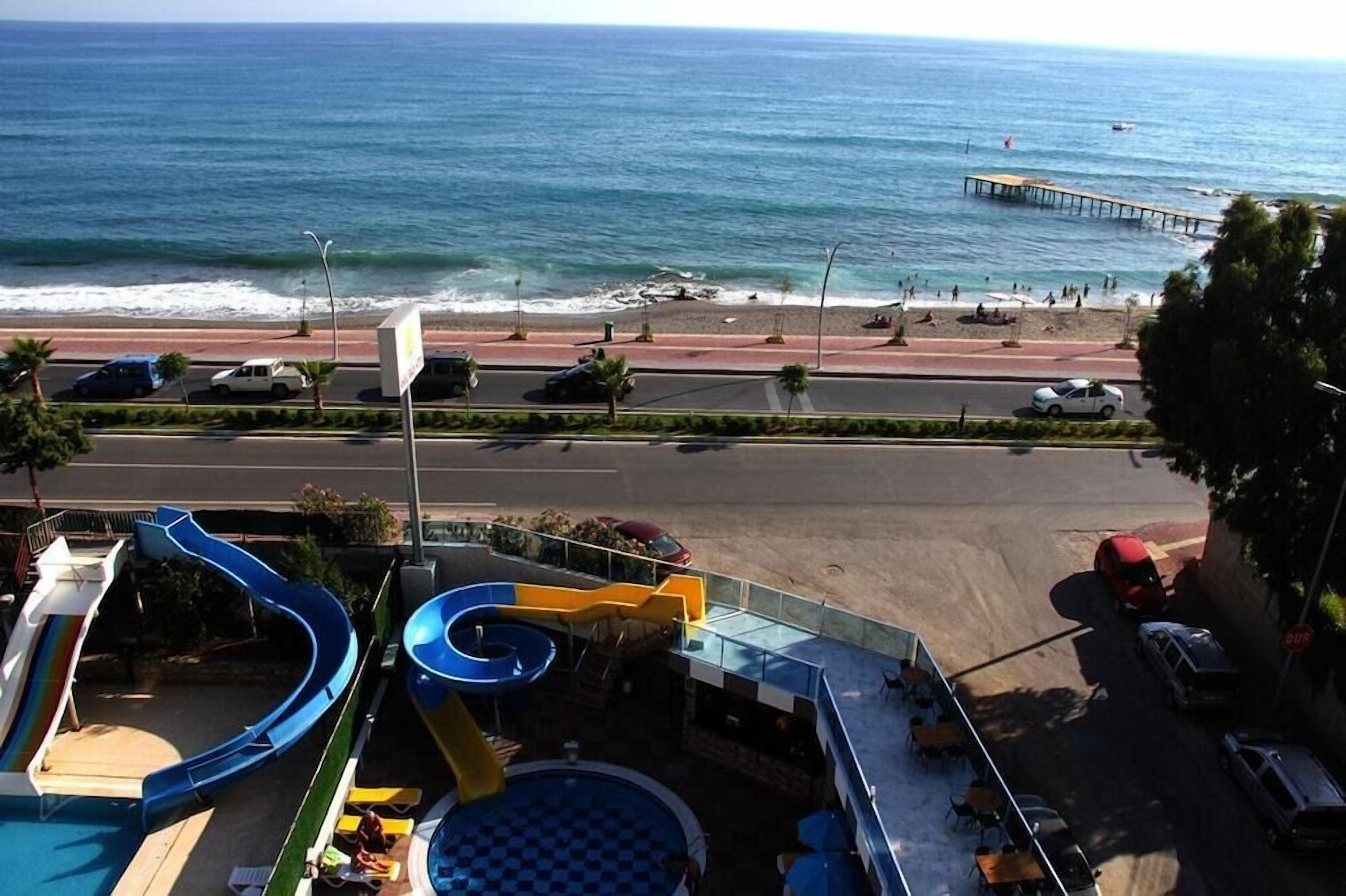 A resort with a pool area, a beach, and a pier.