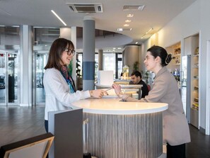 Ein Empfangsbereich mit runder Theke, Glastür und modernem Interieur.
