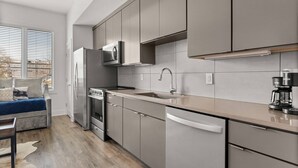 A modern kitchen with stainless steel appliances, a built-in oven, and a coffee maker.