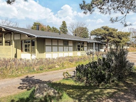 A row of single-story buildings with a simple, functional design, featuring large windows and a flat roof.