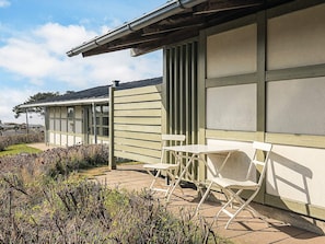 Un edificio con un patio techado y zona de estar al aire libre.