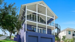 Ein mehrstöckiges Haus mit Balkon, Garage und Wendeltreppe.