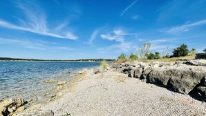 Eine felsige Küstenlinie mit klarem Wasser und einer entfernten Küste.