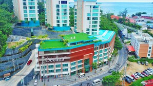 A multi-story hotel with a prominent 'Oceana' sign, featuring a rooftop garden and a curved facade. - Oceana C51 (Kamala)