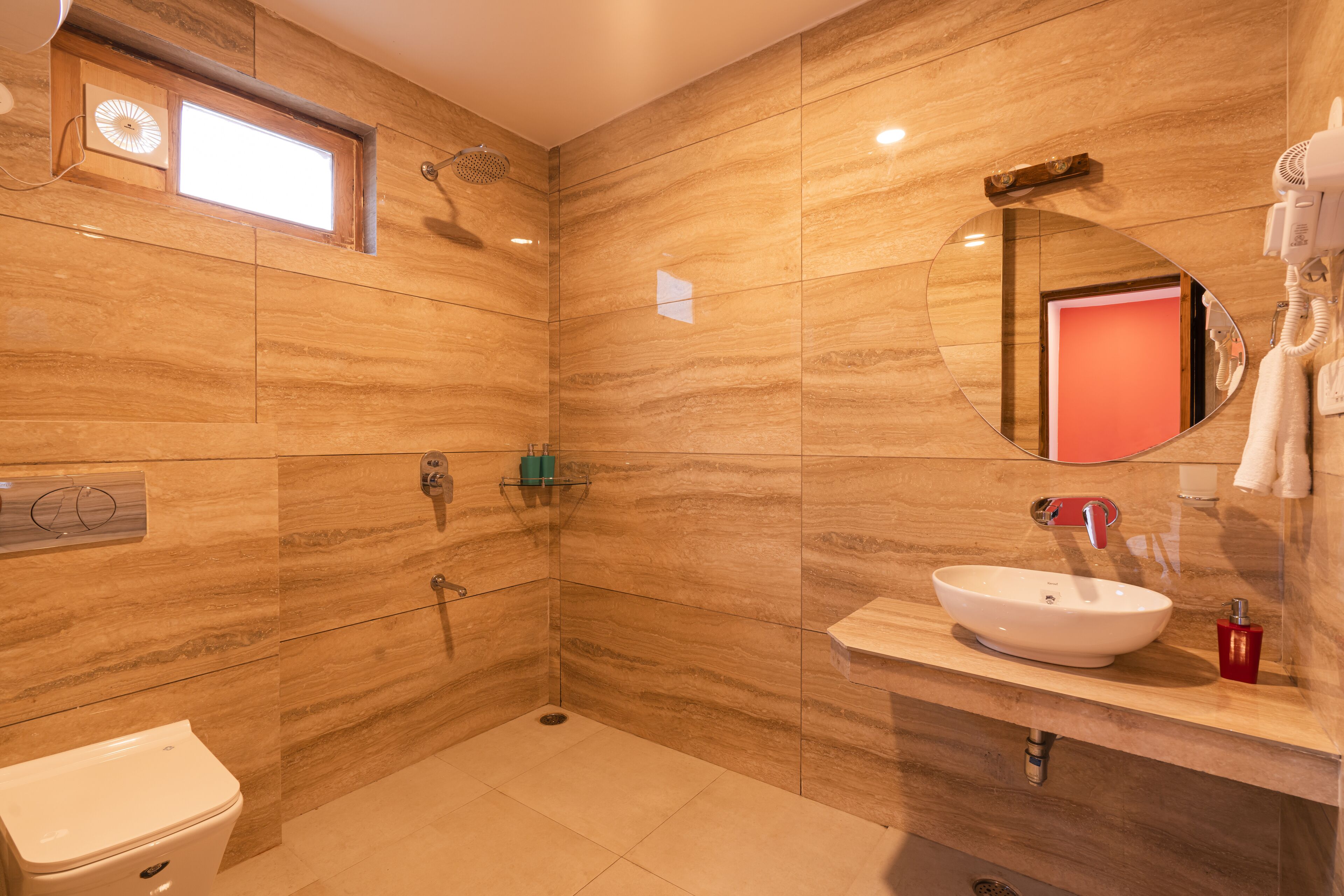 Un baño moderno con un espejo grande, un lavabo y una zona de ducha.