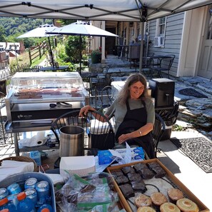 An outdoor food stall with a grill, cooking utensils, and packaged food items.