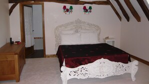 A bedroom with a white ornate bed, a wooden dresser, and a small bedside table. - Luxury gite for adult couples, peaceful, open views, large swimming pool (Boisse)