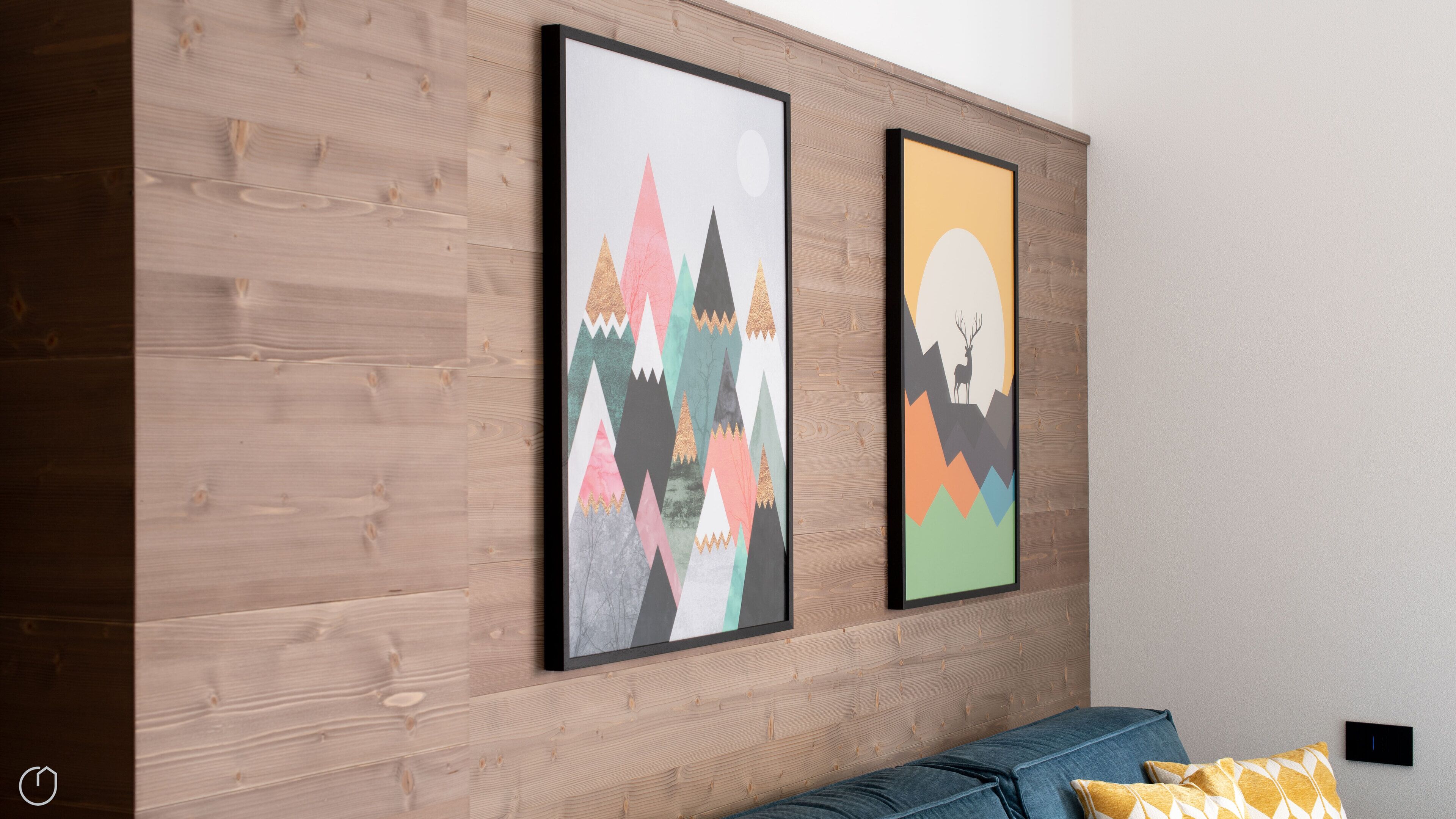 Una habitación con pared de madera y dos cuadros enmarcados.