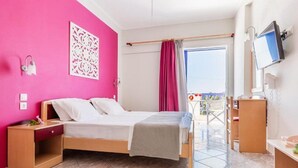 A bedroom with a bed, bedside table, and a TV. - Oniro Pension (Alonissos)