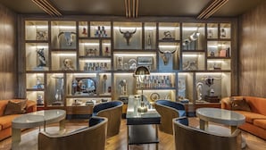 Una sala de estar moderna con una mesa central, dos sofás y una estantería con objetos decorativos.