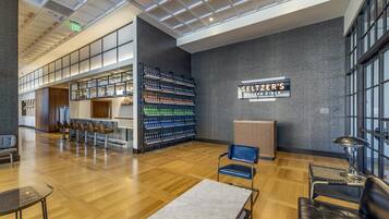 Um interior moderno com área de recepção, assentos e bar.