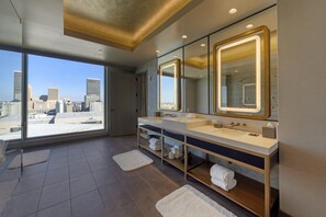 A modern bathroom with a large window, a double sink vanity, and a large mirror. - Omni Oklahoma City Hotel (Oklahoma City)