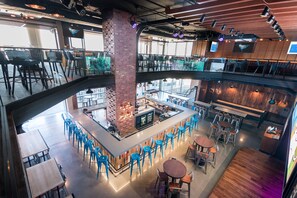 A multi-level restaurant with a central bar area, seating arrangements, and a view of the interior space. - Omni Oklahoma City Hotel (Oklahoma City)