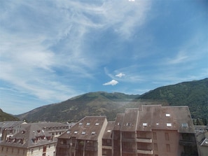 Ein Wohngebiet mit mehrstöckigen Gebäuden, einige davon mit Balkonen, unter einem teils bewölkten Himmel.