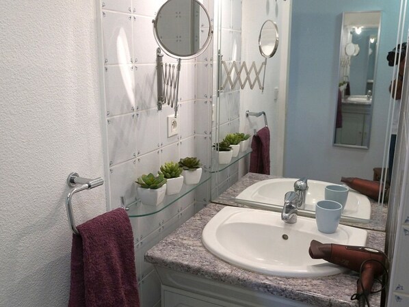 A bathroom with two sinks, a mirror, and a hairdryer on the counter. - Luchon: Appartement 2 Ch, Grand Balcon, Parking, WiFi, Près Thermes (Bagnères-de-Luchon)