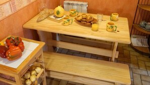 A wooden breakfast table with bread, pastries, and a fruit bowl. - Central Luchon Studio for 2 - Balcony - Near Gondola (Bagnères-de-Luchon)