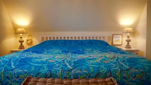 A bedroom with a large bed, two bedside lamps, a white headboard, and a framed picture on the wall. - Windrose, Deutschland (Breege)