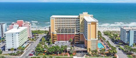 Un hotel con piscina, vistas a la playa y aparcamiento.