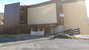 Un bâtiment doté d’un toit plat, d’une enseigne indiquant « PLACE DE PARCEMENT RÉSERVÉE À ‘OLYMPIA’ » et du nom « OLYMPIA B » sur la façade.