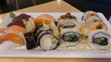 Un plato de sushi con diferentes variedades, incluyendo camarones, salmón y rollos con verduras.