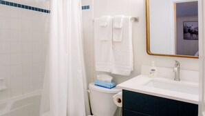 Une salle de bain avec une baignoire, des toilettes, un lavabo et un miroir.