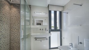 A modern bathroom with a glass shower enclosure, a white sink, and a bidet. - Ático Londres Derecha a Modern 2º floor Penthouse Beachfront in Puerto Pollensa (Puerto Pollensa)