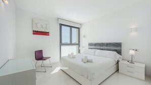 A modern bedroom with a large bed, a desk, a chair, and a window. - Ático Londres Derecha a Modern 2º floor Penthouse Beachfront in Puerto Pollensa (Puerto Pollensa)