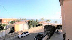 A residential street with a view of the beach, palm trees, and a clear sky. - 036 - Sierramar 001 - comfortHOLIDAYS (Santa Pola)