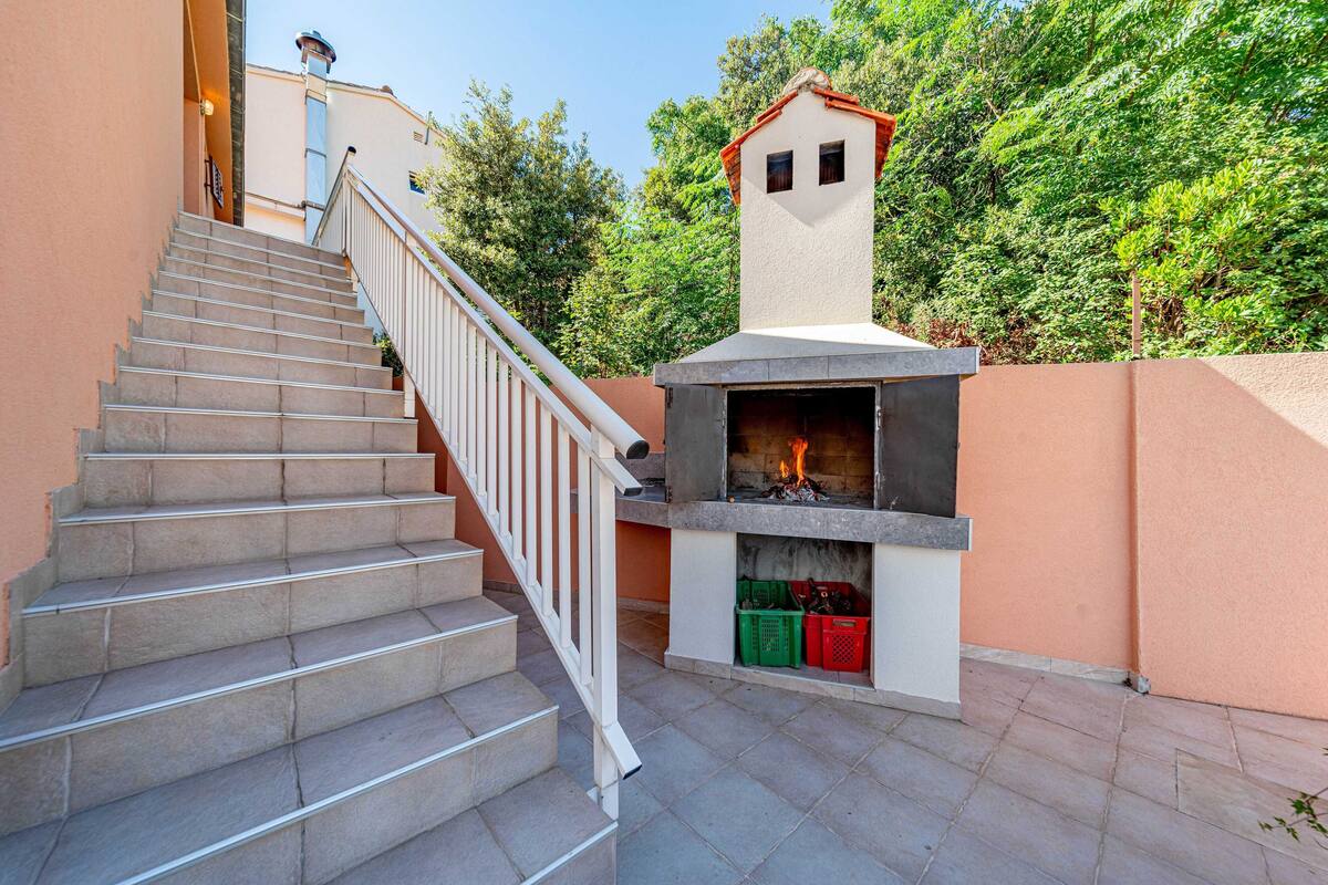 A staircase leading to a building with a stone fireplace and a small tower-like structure.
