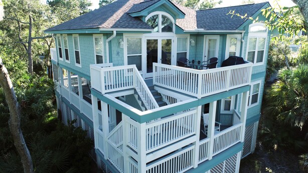 Une maison à plusieurs étages dotée d’un balcon et d’un escalier.