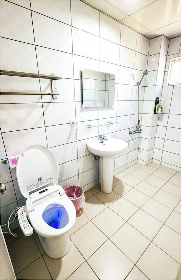 Un baño con inodoro, lavabo y ducha.