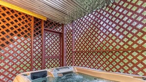 Un bain à remous avec un mur en treillis de bois en arrière-plan.