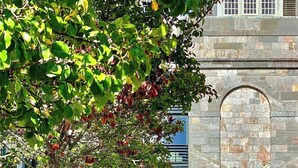 Un bâtiment en pierre doté d’une entrée en arc de cercle et d’une cour dallée.