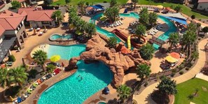 A resort with multiple swimming pools, including a large central pool and a smaller pool with a rock formation. There are lounge areas with umbrellas and sun loungers. - Arcadia 4/5 | Perfect Poolside Location * Sleeps 36 * Balcony Views (Santa Clara)