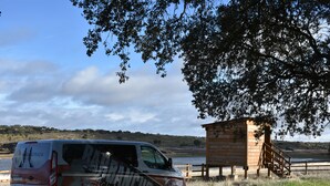 Una camioneta estacionada cerca de una cabaña de madera junto a un lago.