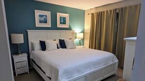 Habitació d'hotel ben ordenada amb llit, taules de nit i un armari.