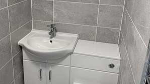 A bathroom with a white sink, mirror, and toilet. - City & Station Stays at Gulland House by Pureserviced (Plymouth)