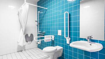 Un baño moderno con inodoro blanco, lavamanos y zona de ducha.