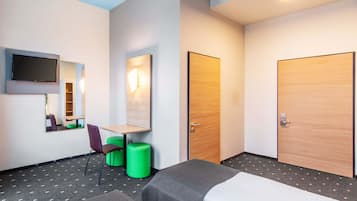 A hotel room with two beds, a desk, a chair, a TV, and a mirror.